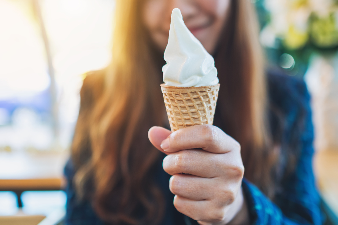 Closeup Image of a Woman Holding and Eating Soft Serve Ice Cream